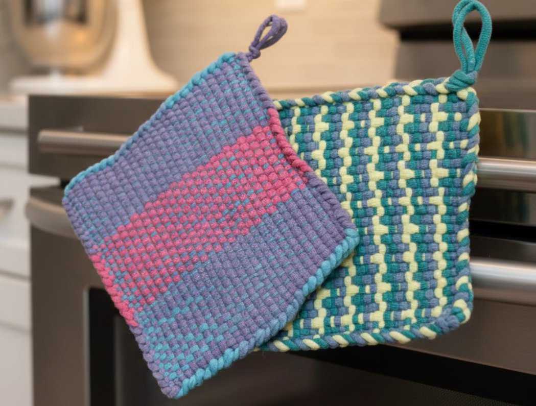 Two woven potholders, one blue and pink, the other green and yellow, on a colorful background.