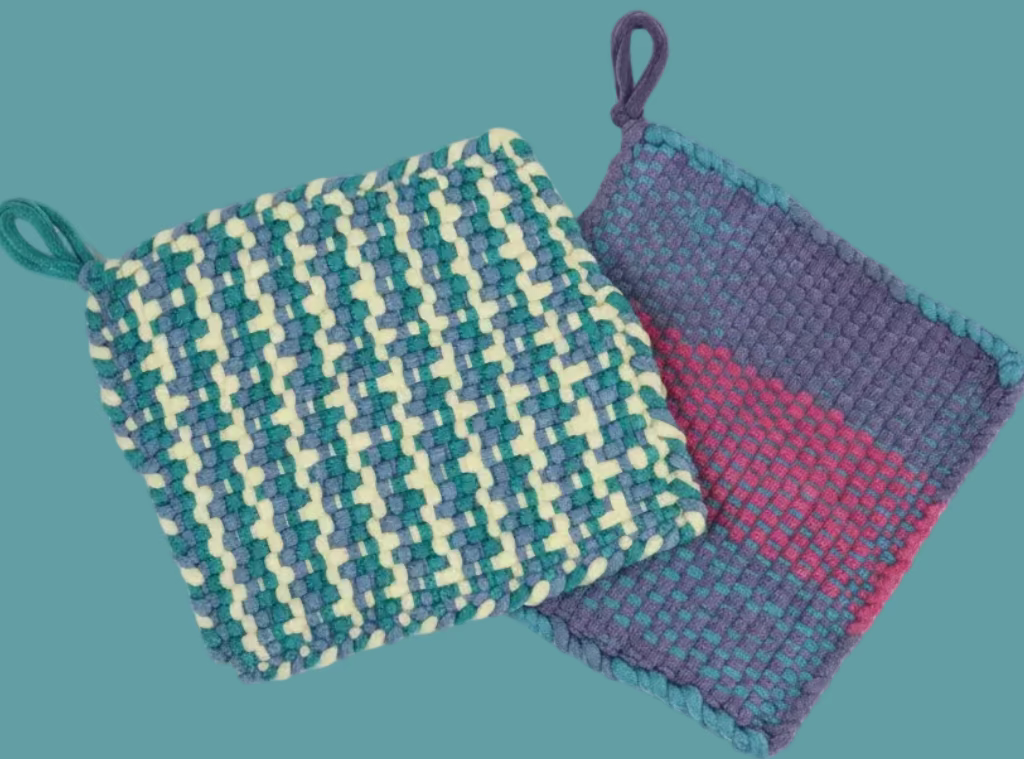 Two woven pot holders on a colorful fabric background