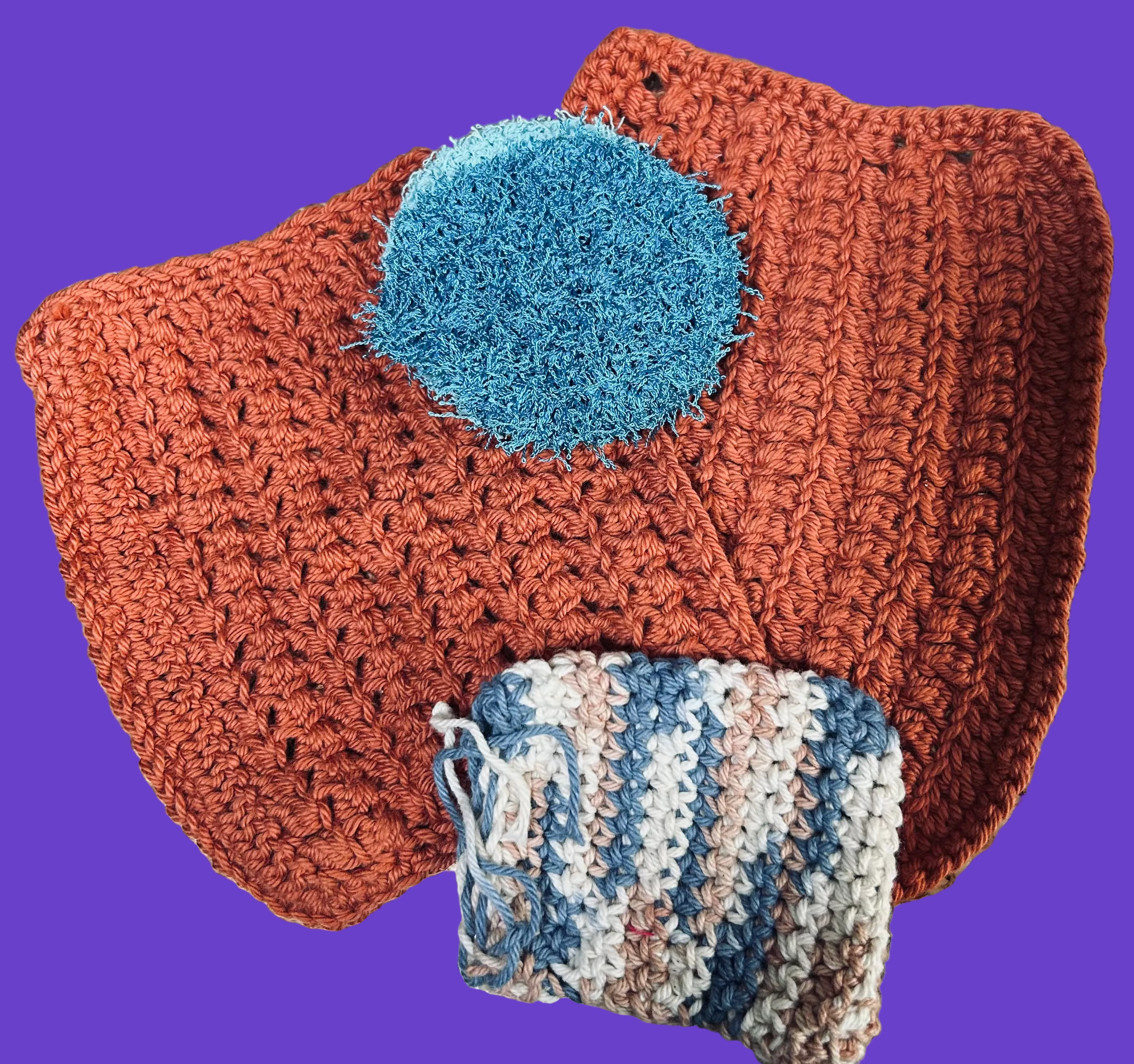 crocheted item with a blue circular patch on a textured surface