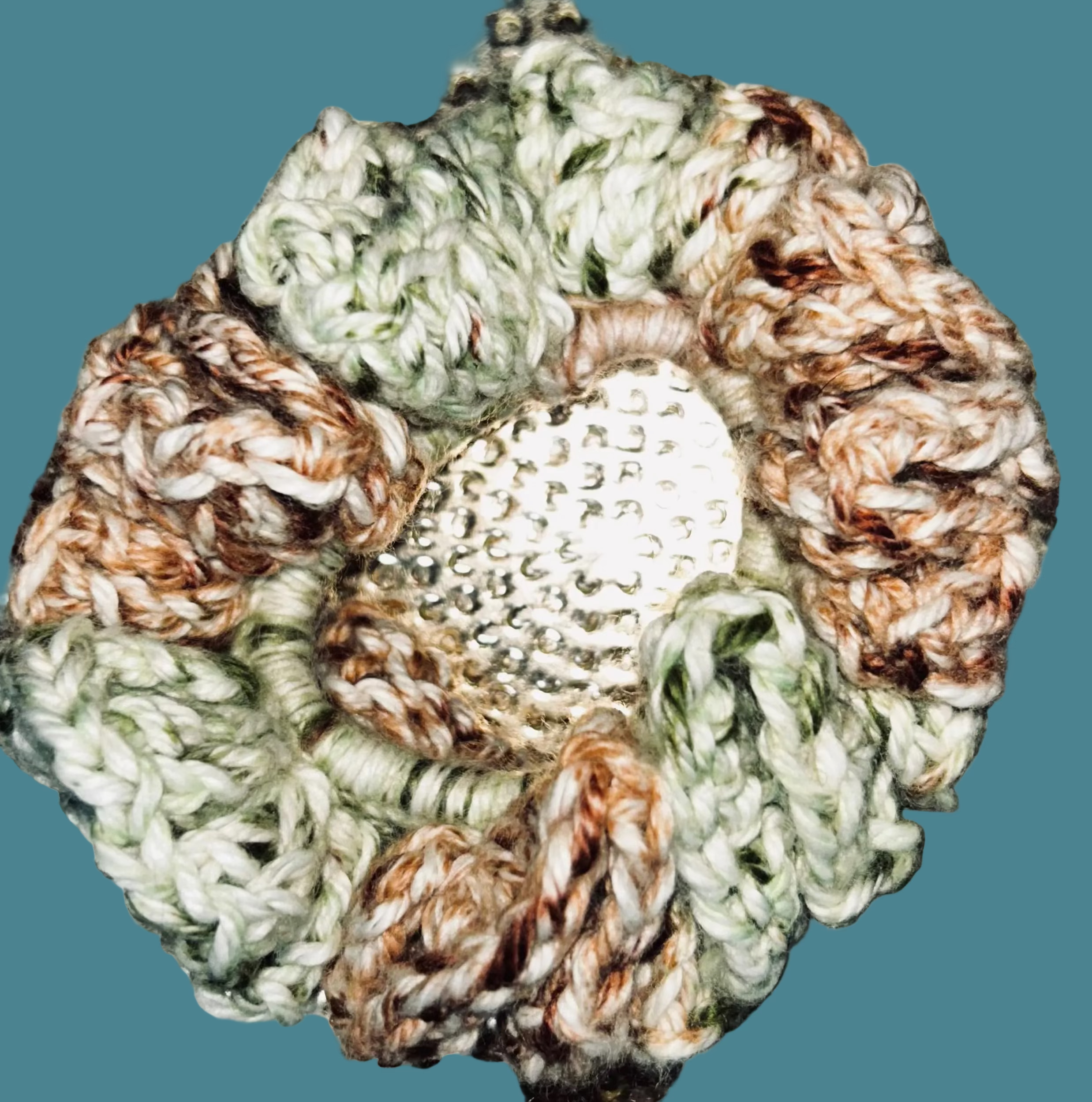 Close-up of a textured surface with a knitted flower brooch.