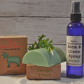 Garden-themed products including a soap bar, plant, and spray bottle on a wooden surface.