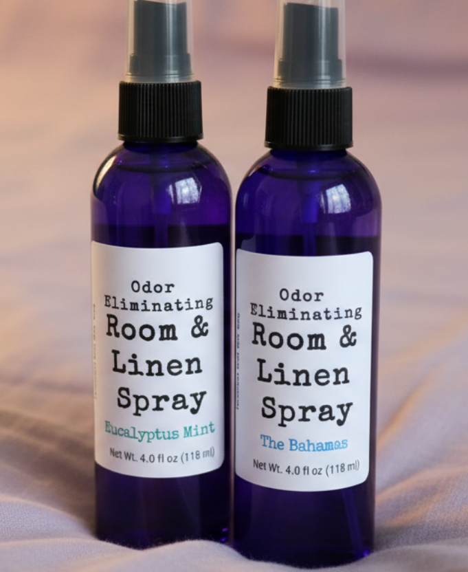 Two bottles of odor eliminating room and linen spray on a white background