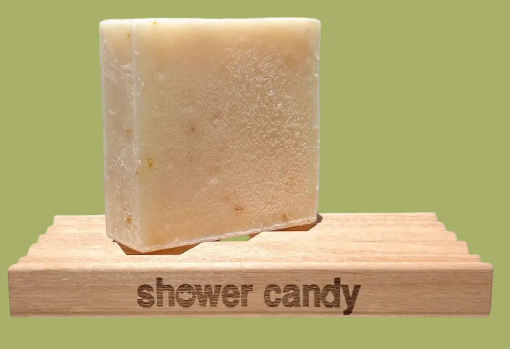 Bar of soap on a wooden block with 'shower candy' branding on a white background