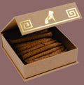 Open brown cardboard box with gold accents containing brown sticks on a light gray background