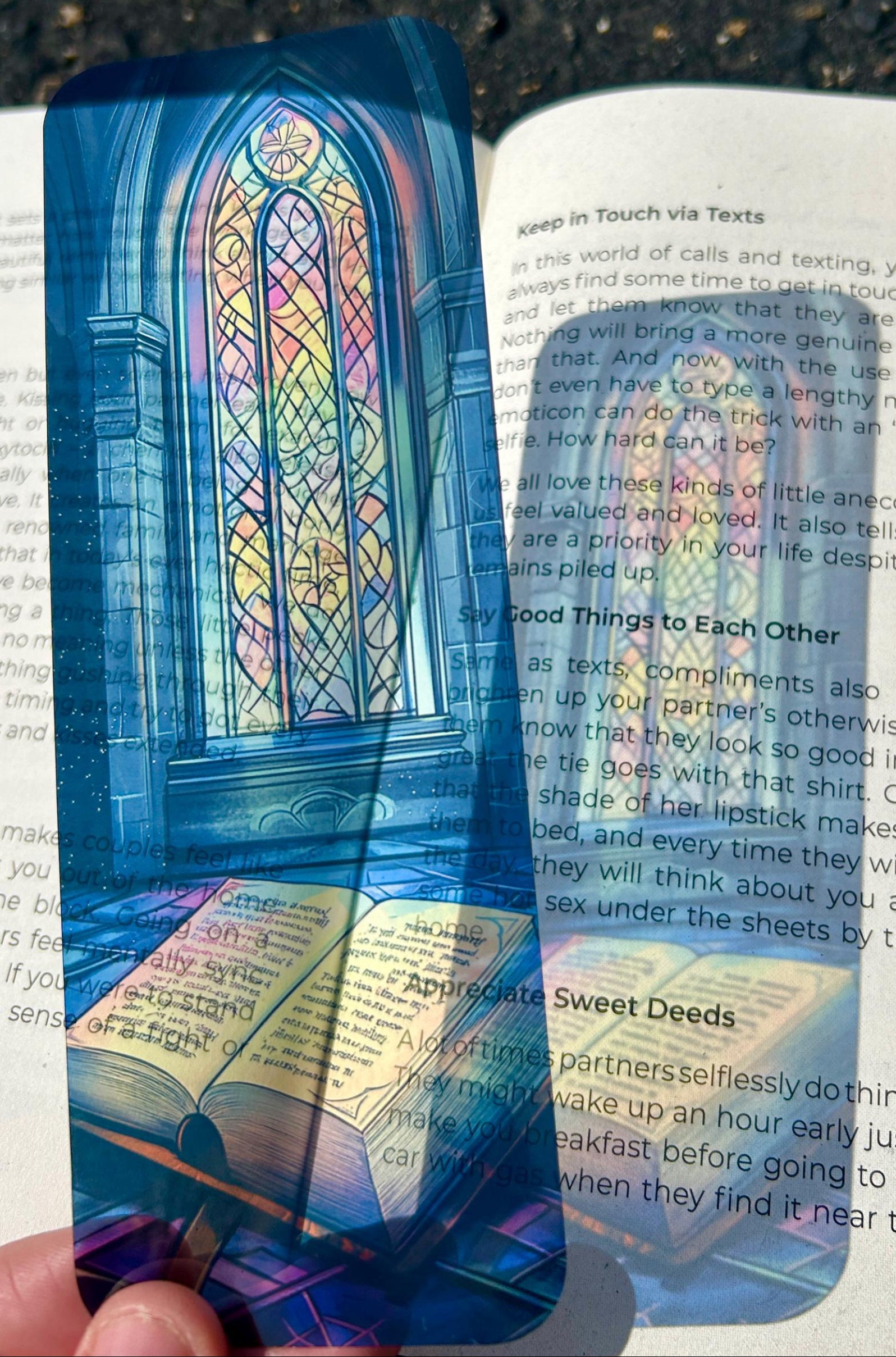 Colorful bookmark with stained glass design held over an open book