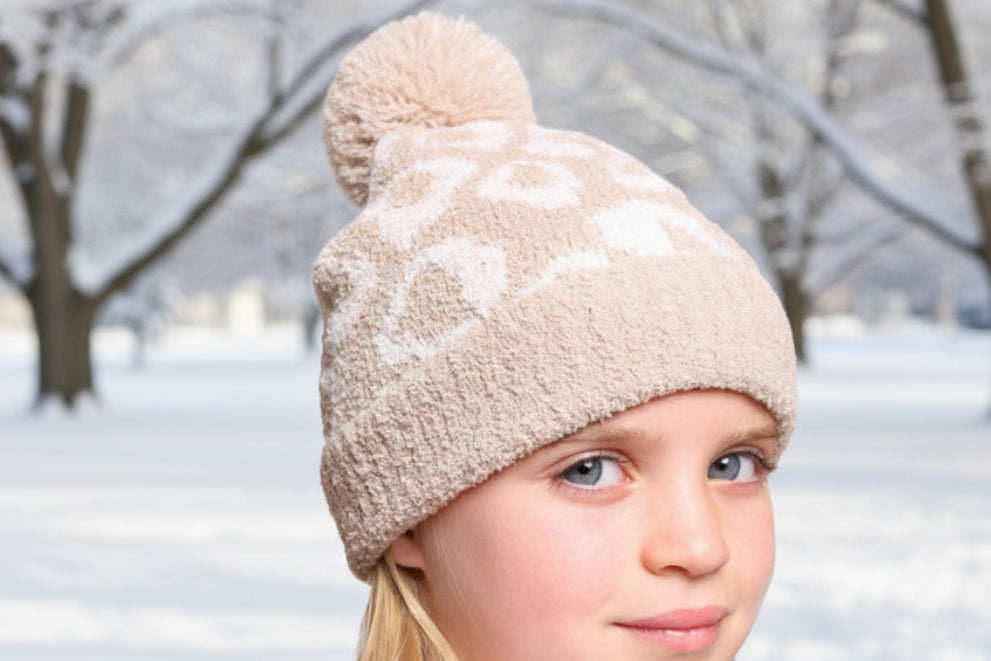 Young girl wearing a beige fleece-lined beanie on a white background