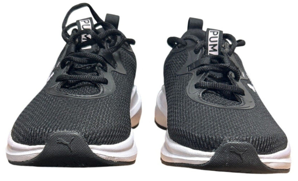 Pair of black athletic shoes with white soles on a white background