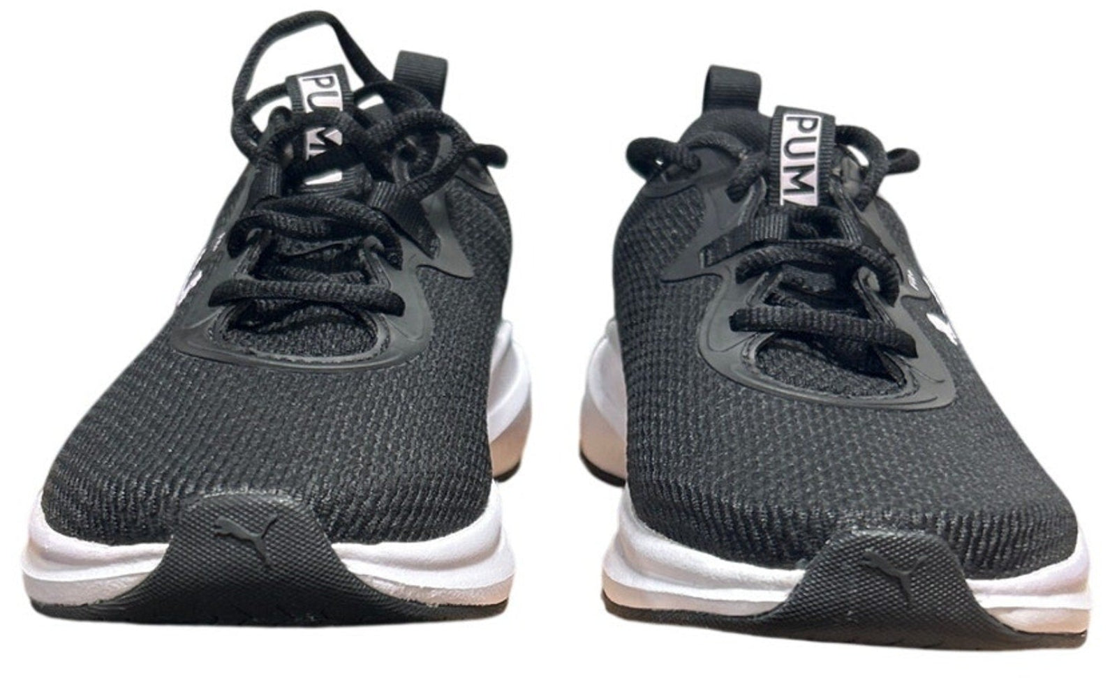 Pair of black athletic shoes with white soles on a white background