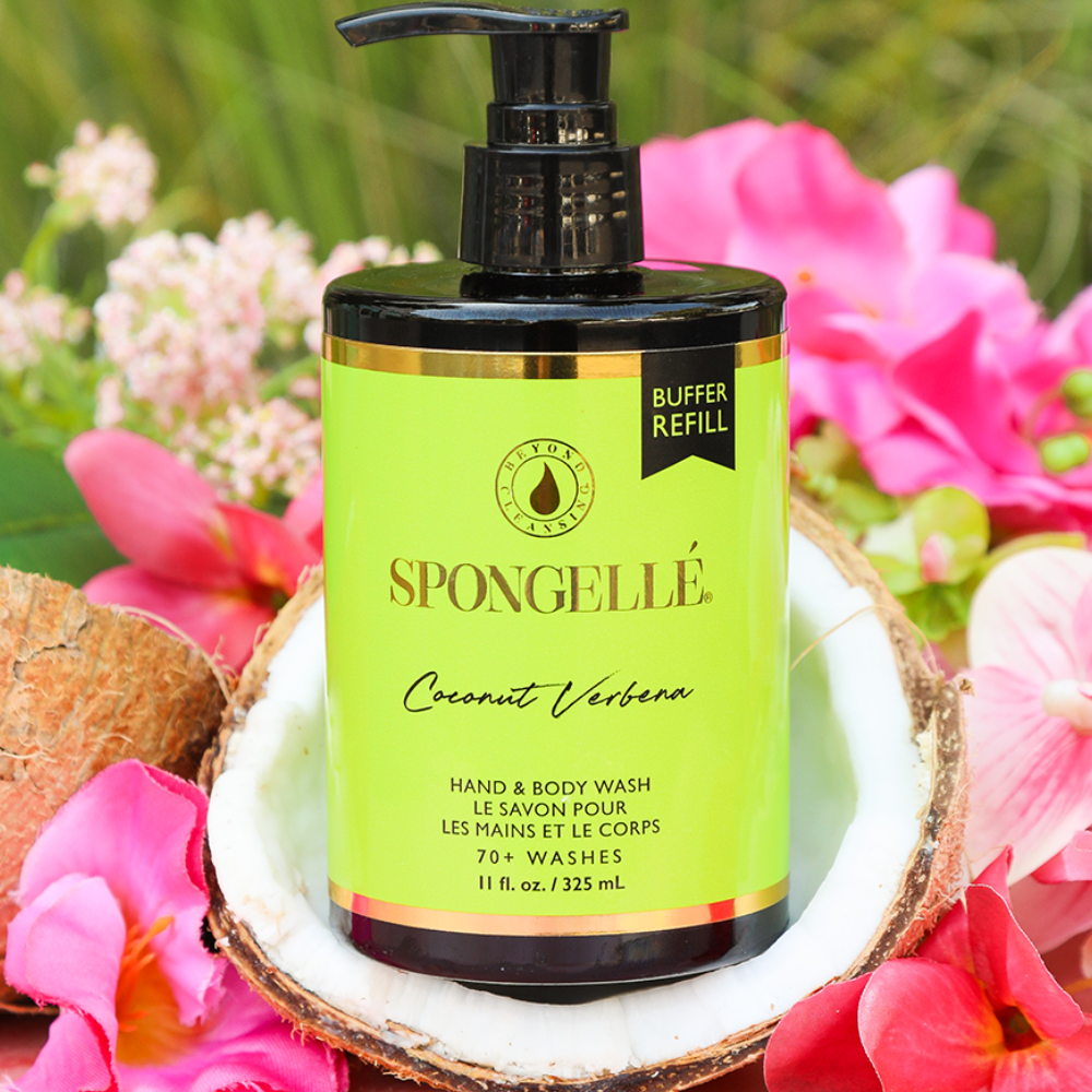 Spongellé Coconut Verbena hand and body wash bottle with a pump on a coconut shell surrounded by flowers.