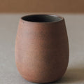 Brown ceramic cup on a neutral background