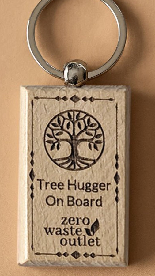 Keychain with 'Tree Hugger On Board' text and tree design on a beige background