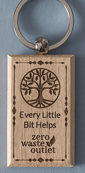 Wooden keychain with tree design and text on a blue background