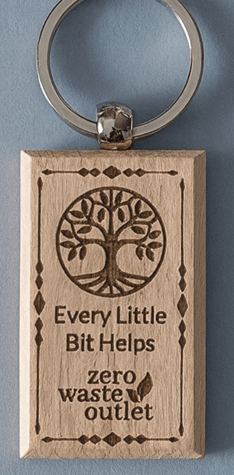 Wooden keychain with tree design and text on a blue background