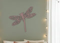 Gold dragonfly-shaped decorative item on a white background