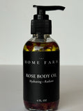 Rose body oil bottle with black pump on a white background