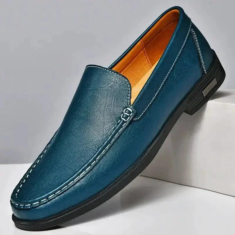 Blue leather loafer shoe on a gray background