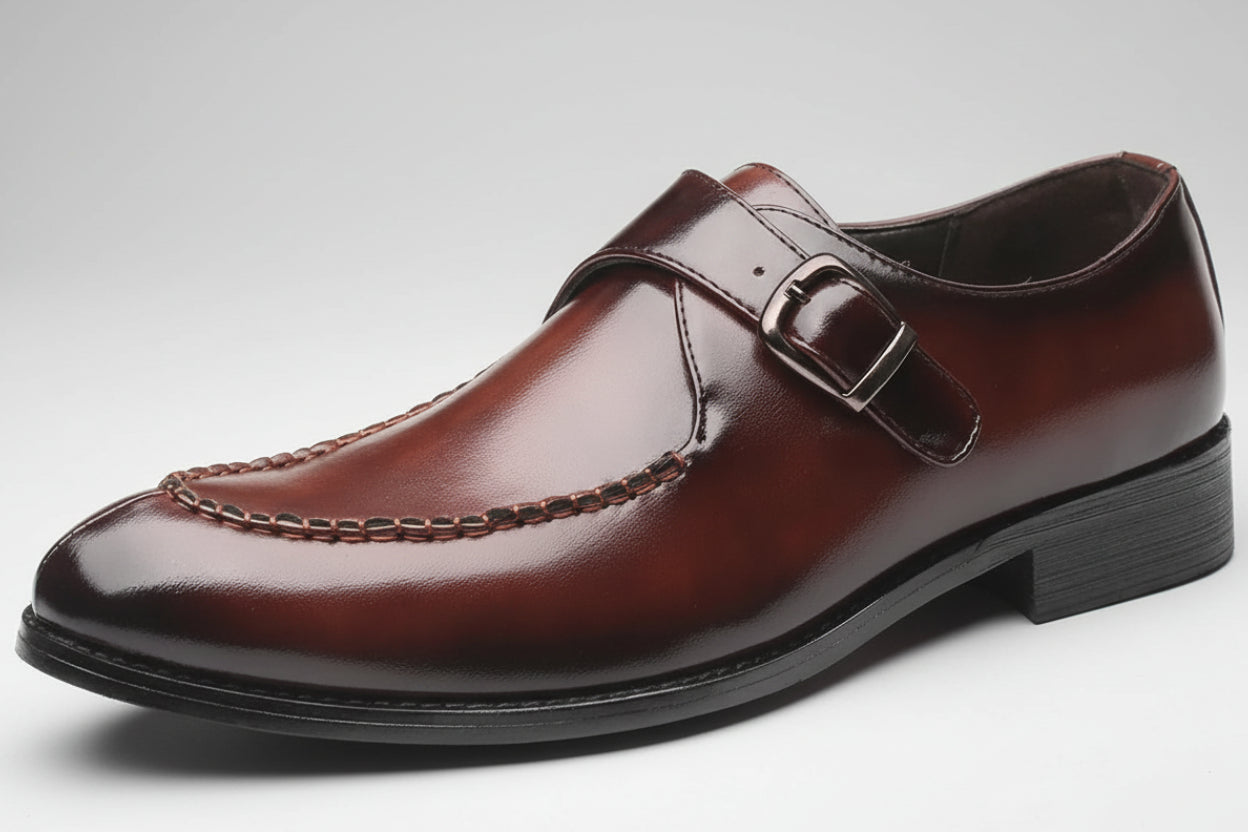 Brown leather dress shoe with a buckle on a white background