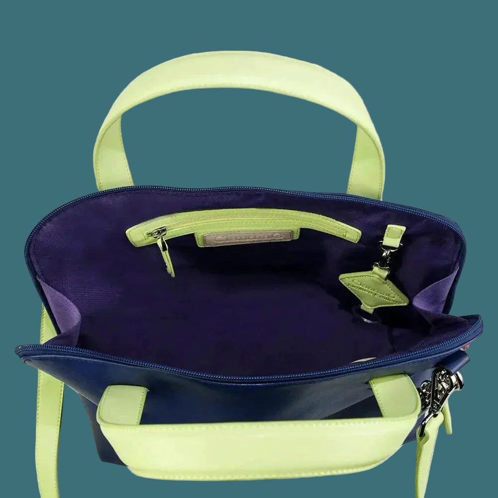 Blue handbag with green handles and trim on a white background