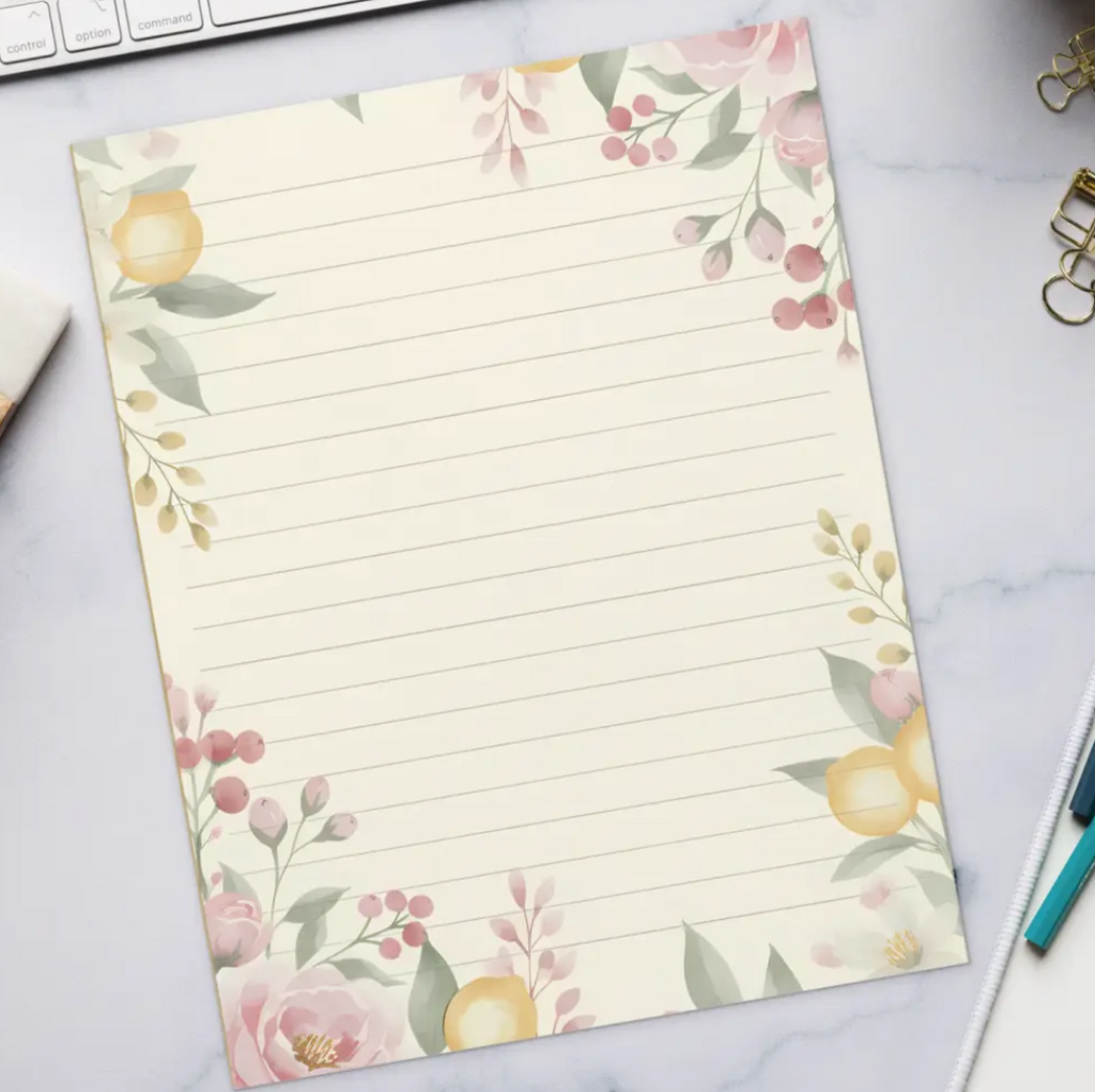 Floral lined paper on a desk with a keyboard, coffee, and office supplies.