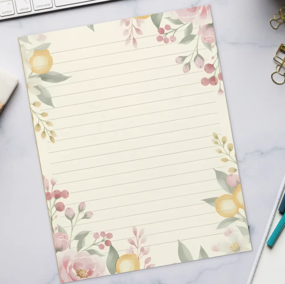 Floral lined paper on a desk with a keyboard, coffee, and office supplies.
