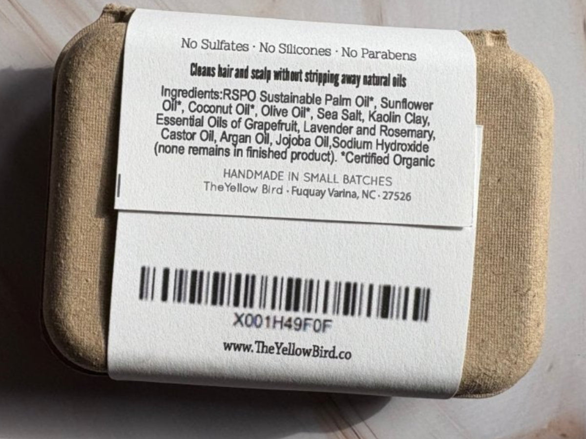 Bar of soap with a label on a light wooden surface
