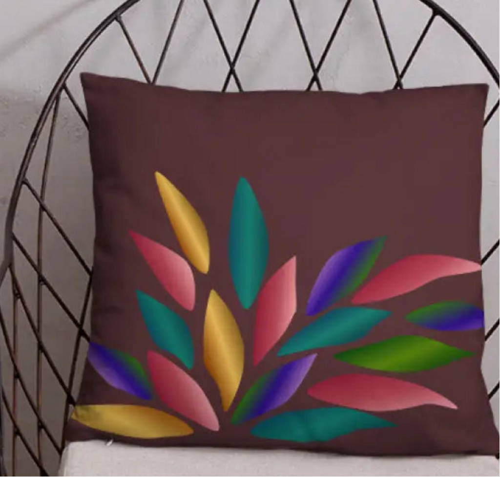 Decorative pillow with colorful leaf design on a wire chair against a light gray wall.