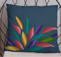 Decorative pillow with colorful leaf design on a wire chair against a light gray wall.