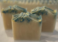 Three rectangular soap bars with green and white swirls on a marble surface.