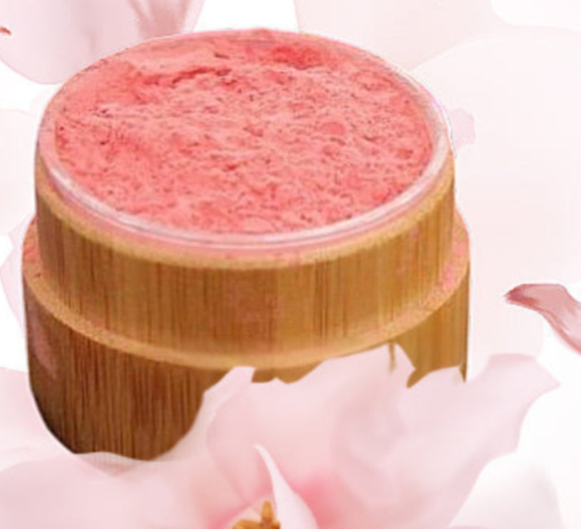 Pink cosmetic product on a wooden stand with cherry blossom petals in the background