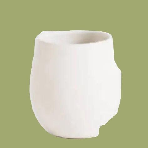 White ceramic cup on a light gray speckled surface