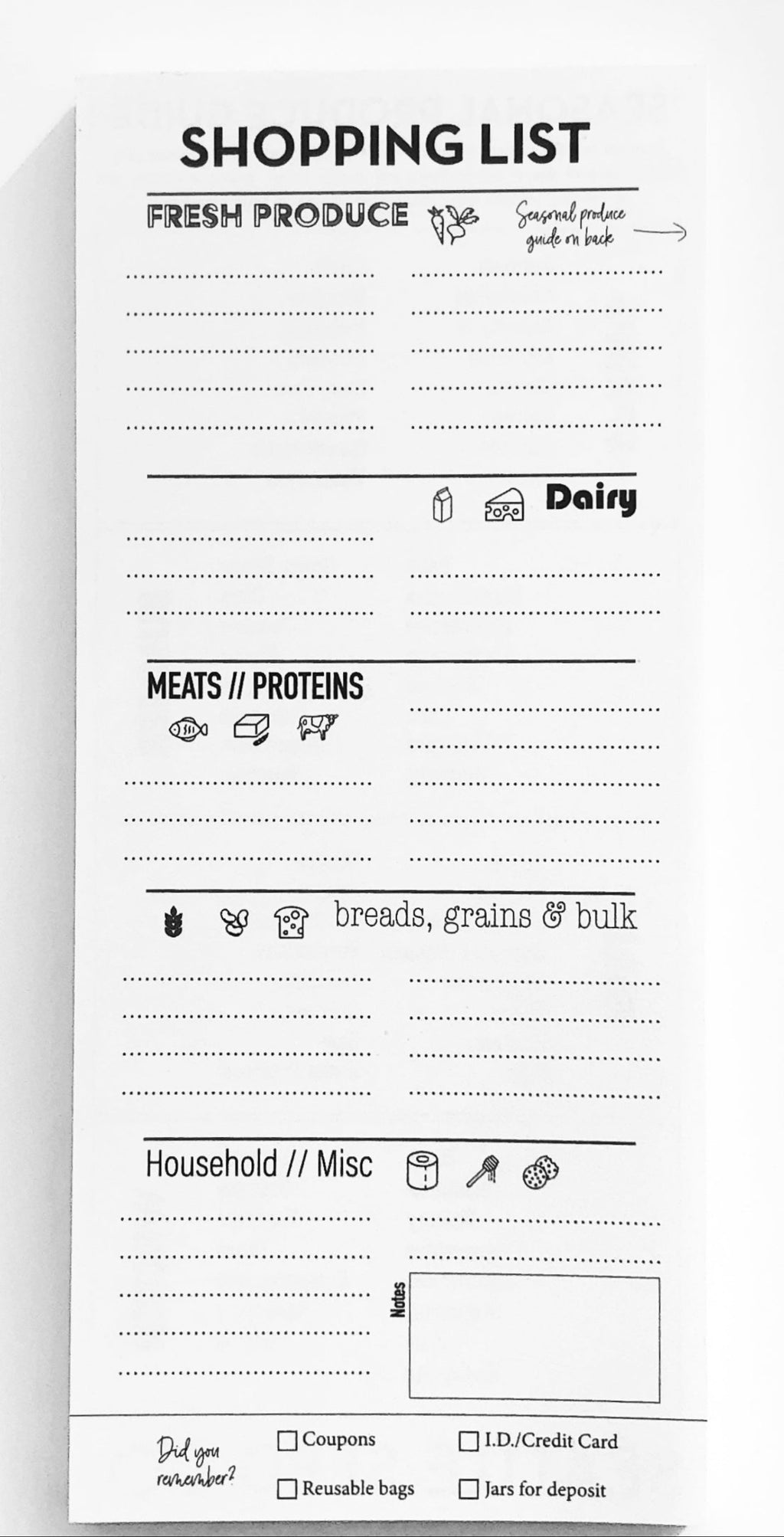 White notepad with black text and icons for a shopping list on a white background