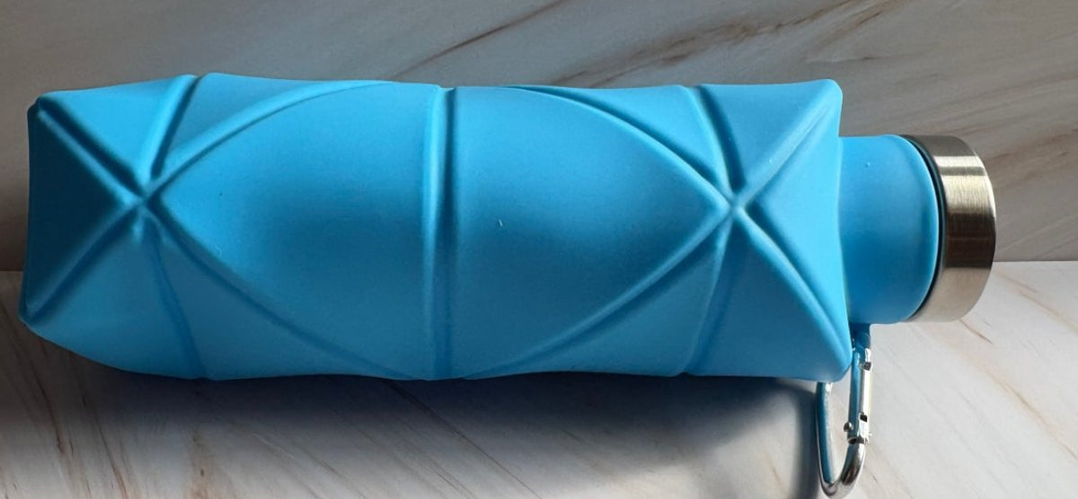 Blue folded umbrella with a gold handle on a wooden surface