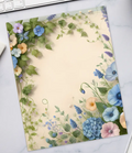 Floral notebook on a desk with a keyboard, coffee, and stationery items.