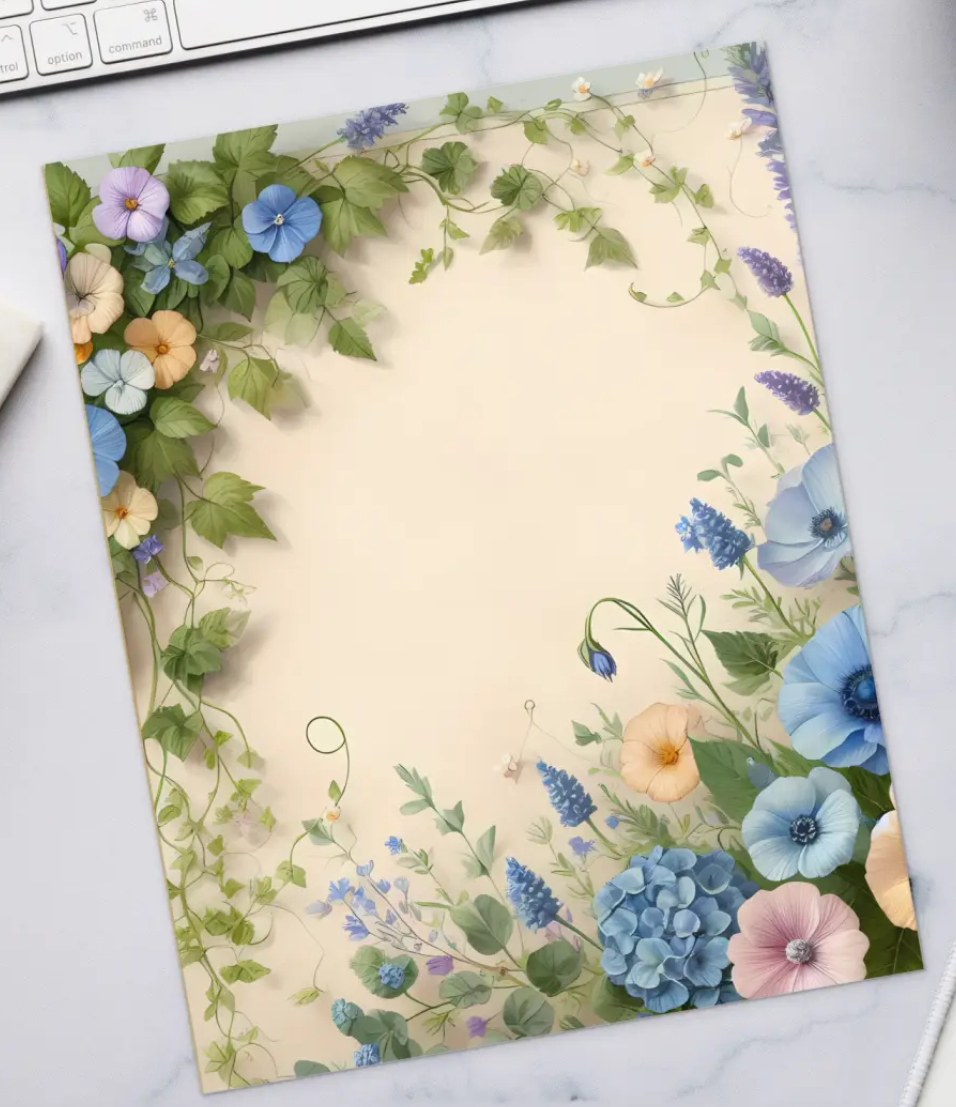 Floral notebook on a desk with a keyboard, coffee, and stationery items.