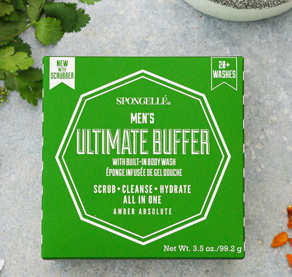 Green box of Spongellé Men's Ultimate Buffer on a gray surface with natural elements.